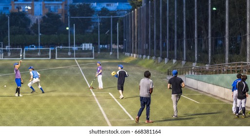 TOKYO, JAPAN - JUNE 28TH 2017. Players Practicing Baseballs At Night. Baseball Is A Popular Sport In Japan.