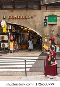 Tokyo, Japan - March 01 2020: Japanese Woman In Hakama Kimono Reading A Travel Tokyo Guide Book At Retro Underpass Yuraku Concourse Of  Yurakucho Station. 