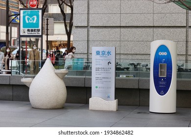 TOKYO, JAPAN - March 10, 2021: A Water Fountain And A Water Refill Station At Tokyo International Forum Which Provides Free Cold Water. A Tokyo Metro Subway Station Entrance Is Behind Them. 