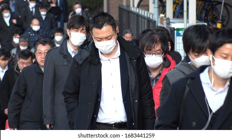 TOKYO, JAPAN -MARCH 2020 : Crowd Of People Walking Down The Street In Busy Morning Rush Hour. Many Commuters Going To Work. People Wearing Surgical Mask To Protect From Coronavirus(COVID-19) Or Cold.