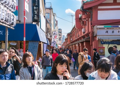 Tokyo, Japan - March 24, 2019: Narrow pedestrain street lined with shops and restaurant and crowed with people in Asakusa, a district of Tokyo famous for the Sensō-ji  Buddhist temple.