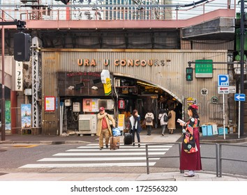 Tokyo, Japan - March 25 2020: Japanese Woman In Hakama Kimono Reading A Travel Guide Book At Retro Underpass Yuraku Concourse Of  Yurakucho Station. 