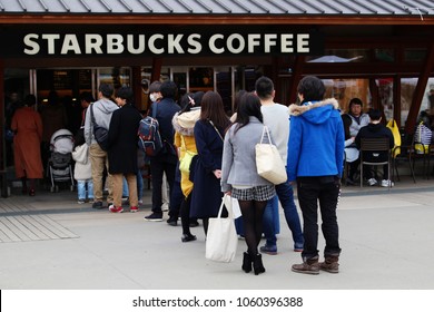 
TOKYO, JAPAN - March 3, 2018: A Long Line Of Customers Outside A Busy Starbucks Branch In Tokyo's Ueno Park.