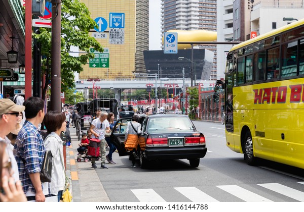 TOKYO, JAPAN - MAY 12, 2019 :A\
Japanese taxi and crowd in the old town Asakusa commercial area in\
front of Sensoji Temple, where located in Tokyo city\
Japan.