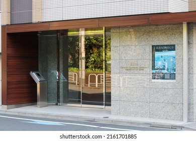 TOKYO, JAPAN - May 5th, 2022: Entrance to a modern apartment block in Tokyo's Koto Ward. There's a poster advertising a new apartment building on the wall.