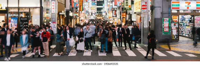 Tokyo, Japan - Nov 1, 2019: Motion blur of crowded Asian people, traveler walking at Kabuki-cho district. Japanese nightlife culture, Tokyo tourist attraction, or Japan travel concept. Banner size