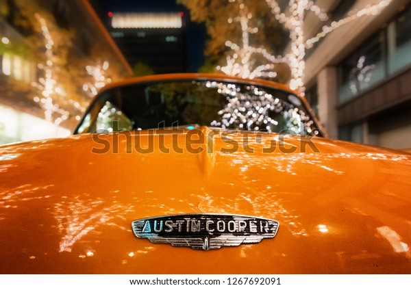 TOKYO, JAPAN - NOV 25: Classic yellow Mini\
Cooper parked on display near Tokyo Station with Christmas seasonal\
lights in background November 25,\
2018.