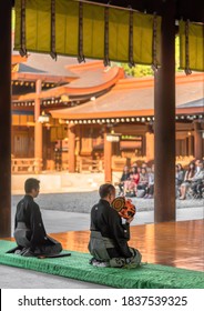 Tokyo, Japan - November 02 2019: Japanese Man Sitting In Seiza Pose Playing A Kagura Dance Rhythm On A Traditional Japanese Tsuzumi Drum In Shinto Meiji-jingu Shrine For Emperor Meiji's Birthday