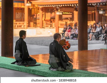 Tokyo, Japan - November 02 2019: Japanese Man Sitting In Seiza Pose Playing A Kagura Dance Rhythm On A Traditional Japanese Tsuzumi Drum In Shinto Meiji-jingu Shrine For Emperor Meiji's Birthday