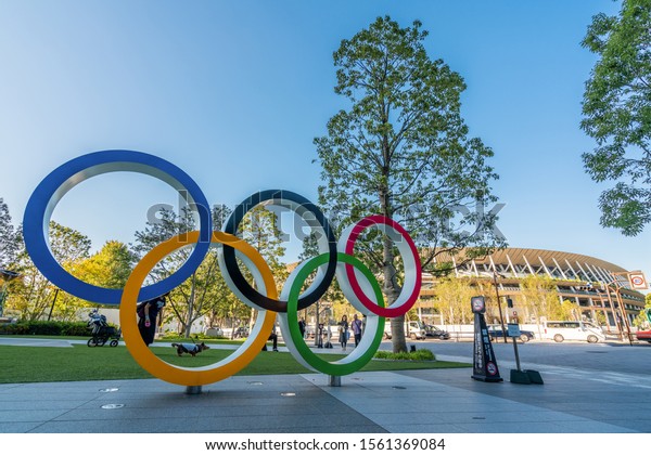 TOKYO, JAPAN -\
November 1,2019 : The five ring symbol of the Olympic Games at\
tokyo museum and new stadium in background. Japan will host the\
Tokyo 2020 summer olympics and\
Paralympic.
