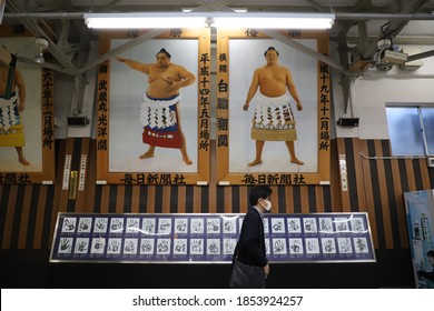 TOKYO, JAPAN - NOVEMBER 14th 2020: Man Walking To Catch The Train In The Train Station Of Ryogoku. This Station Is Famous Because Of The Sumo Wrestling Stadium. That Explains The Sumo Decoration