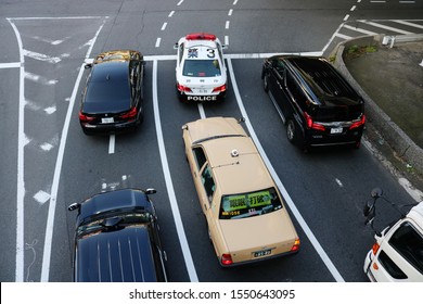 TOKYO, JAPAN - November 2, 2019: Overhead View Of Vehicles, Including A Taxi And A Police Car, At A Junction In Tokyo's Shimbashi / Ginza Area.