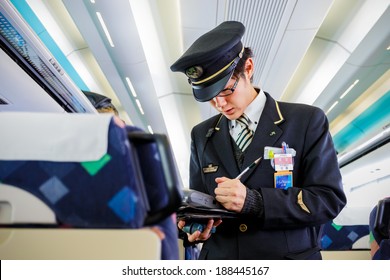 TOKYO, JAPAN - NOVEMBER 23: Train Steward in Tokyo, Japan on November 22, 2013. Train steward of JR train checks for ticket and makes fare adjustment for passenger