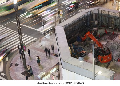 TOKYO, JAPAN - November 26, 2021: Overhead View Of A Corner Of Ginza's Sukiyabashi Crossing Including An Excavator On The Ginza Sony Park Construction Site. Some Motion Blur And Light Trails.