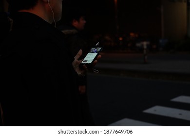 Tokyo, Japan - November 30th 2017: Japanese Man Using Smartphone At Crosswalk In Tokyo. Watching Youtube On The Phone