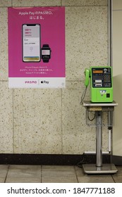 TOKYO, JAPAN - November 4, 2020: Public Pay Phone By A Poster Advertising Digital Payments Using The Iphone And Apple Watch With Apple Pay And Pasmo. It Is Inside Iidabashi Subway Station.