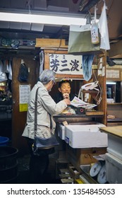Tokyo, Japan - Oct 29, 2016: Two man having a business talk over the booth in the famous Tsukiji fish market. Tsukiji fish market is famous sprawling wholesale fish market with an array of seafood.