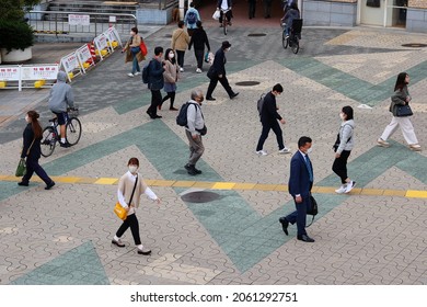 TOKYO, JAPAN - October 21, 2021: Overhead View Of People Walking Towards Tokyo's Ueno Station. Some Motion Blur.