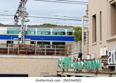 TOKYO, JAPAN - October 21, 2021: Front of Ueno Station with a Joban Line train double-decker train departing in the background. Focus is on the foreground. Some motion blur.