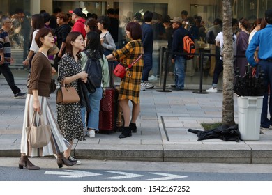 TOKYO, JAPAN - October 27, 2019: The Apple Store In Ginza And The Busy Sidewalk In Front Of It. People On The Left Are Waiting In Line To Buy The Latest IPhones. 