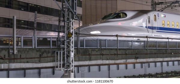 TOKYO, JAPAN - SEPTEMBER 15TH, 2018. Japan High Speed Bullet Train Passing Through Yurakucho Station Railway Track At Night. Selective Focus.