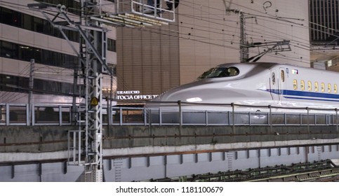 TOKYO, JAPAN - SEPTEMBER 15TH, 2018. Japan High Speed Bullet Train Passing Through Yurakucho Station Railway Track At Night. Selective Focus.