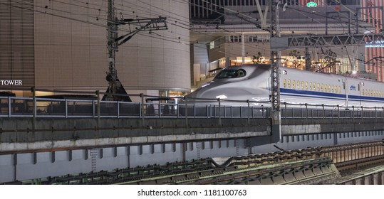 TOKYO, JAPAN - SEPTEMBER 15TH, 2018. Japan High Speed Bullet Train Passing Through Yurakucho Station Railway Track At Night. Selective Focus.