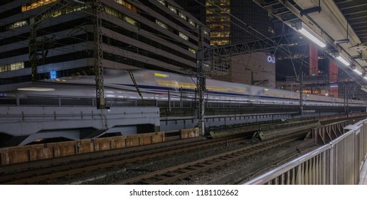 TOKYO, JAPAN - SEPTEMBER 15TH, 2018. Blurred Motion Image Of Japan High Speed Bullet Train Passing Through Yurakucho Station Railway Track At Night.