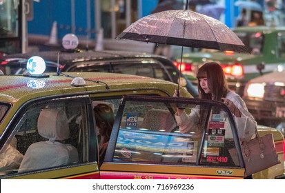 TOKYO, JAPAN - SEPTEMBER 16TH, 2017. Japanese Girls Getting Into A Taxi During A Rainy Night In Shibuya.