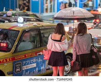 TOKYO, JAPAN - SEPTEMBER 16TH, 2017. Japanese Girls Getting Into A Taxi During A Rainy Night In Shibuya.