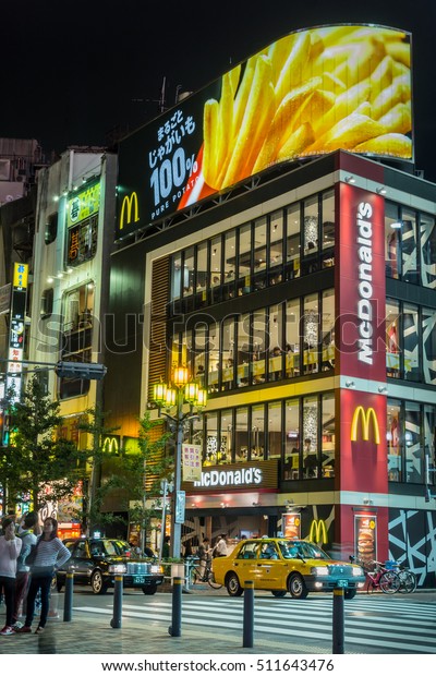 Tokyo, Japan - September 29, 2016:\
Night photo of the four-level McDonalds restaurant at Shinjuku\
intersection. Cars, people, bright neon signs and black\
sky.