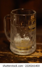 Tokyo, Japan, September 6 2013: Almost Empty Jar Of Cold Kirin Beer On A Wooden Table In An Izakaya, With Focus On The Word Kirin