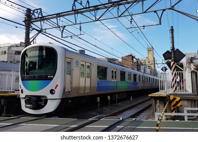 Tokyo, JP - OCTOBER 31, 2018: The New Modern Blue Express Train Running Over Crossing Road On Seibu Ikebukuro Line.