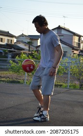 Tokyo,Japan-April 27,2012:a Man Playing Soccer In The Evening In The Parking Lot Of An Apartment In The Tokyo Area, Japan