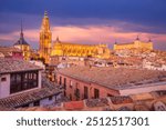 Toledo, Spain. Dramatic aerial view of the medieval Toledo Cathedral and Alcazar fortress, twilight colored sky, Castilla La Mancha.