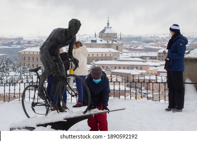 Toledo, Spain. January, 9, 2021.- A boy takes snow from the Federico Martín Bahamontes sculpture, the first spanish cyclist winner in the Tour de France, after a heeavy snowfall