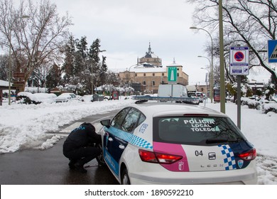 Toledo, Spain. January, 9, 2021.- A Police Officer Fits Snow Chains In The Police Car In The Streets Of Toledo After A Heavy And Historic Snowfall