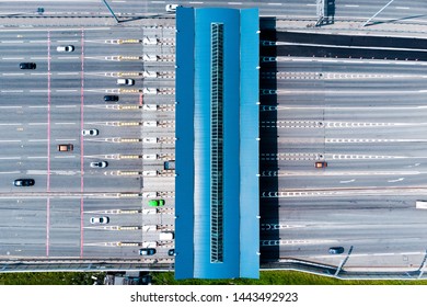 Toll roads on the broad highway. Through the point passes a large number of trucks and cars. Top down view from quadcopter