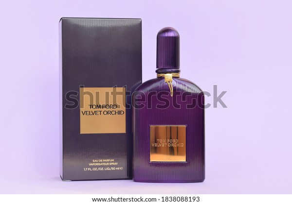 Tom Ford velvet orchid\
fragrance perfume bottle lies on light lilac background. Tom Ford\
is American fashion designer launched his eponymous luxury brand in\
2006