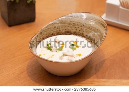 Tom Kha soup with coconut milk with chicken and herbs on a table, Thai cuisine. Tom Kha Gai Soup in bowl. Hard light. Foto stock © 