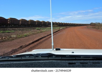 TOM PRICE,WA - JUNE 11 2022:POV of a car driving on the rail access road the world's largest private rail network with over 1400km of tracks connecting mines at Tom Price with Dampier and Port Lambert