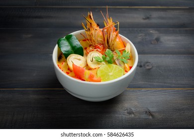 Tom Yum Goong Spicy Sour Soup on wooden table, Thai local food - Shutterstock ID 584626435