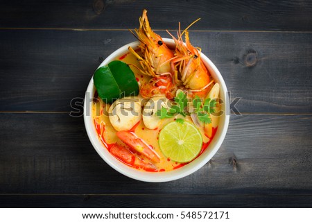 Tom Yum Goong Spicy Sour Soup on wooden table top view, Thai local food