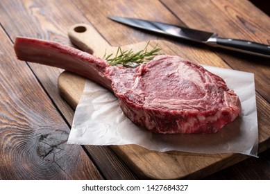 Tomahawk Ribeye Steak On Wooden Cutting Board 