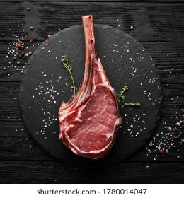 Tomahawk steak. Raw steak on a black background. Top view. Free copy space. - Powered by Shutterstock