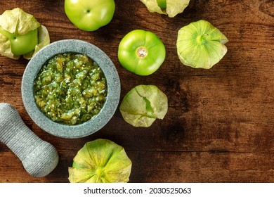 Tomatillos, Green Tomatoes, With Salsa Verde, Green Sauce, In A Molcajete, Traditional Mexican Mortar, Overhead Flat Lay Shot With A Place For Text