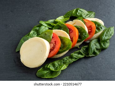 Tomato Basil Mozzarella Garlic On A Dark Background