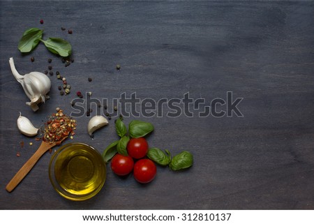 Tomato, basil and pepper with garlic on dark background