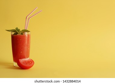 Tomato And Basil Smoothie. Tomato Fresh. A Glass, A Peace Of Tomato, Basil Leaves. Horizontal Orientation, Copy Space. Yellow Background