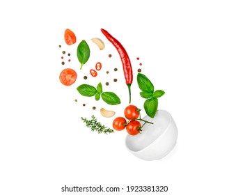 Tomato, basil, spices, chili pepper, garlic fresh thyme flying. Vegan diet food isolated on white. Falling into bowl, levitation fly. Creative concept. High quality photo